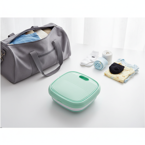 Foldable washing machine collapsed flat next to travel bag – portable and travel-friendly